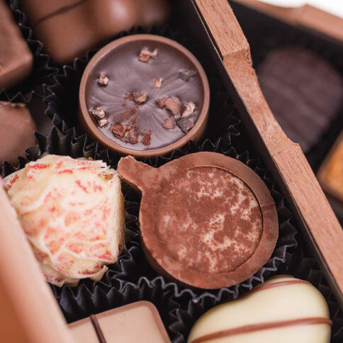 oryginalne czekoladki, czekolada zapakowana w drewno, drewniane skrzynka z pralinkami